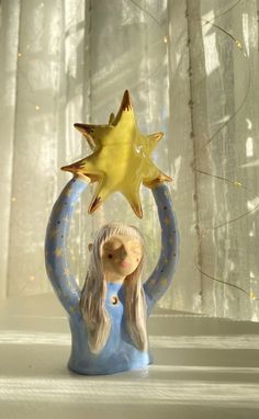 a ceramic figurine holding a star above its head