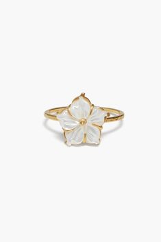 a gold ring with white flowers on the front and center, set against a white background