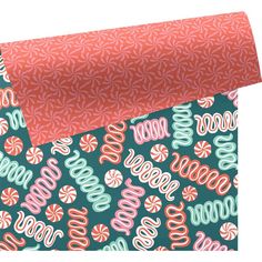 two pieces of wrapping paper on top of each other, one with pink and green designs