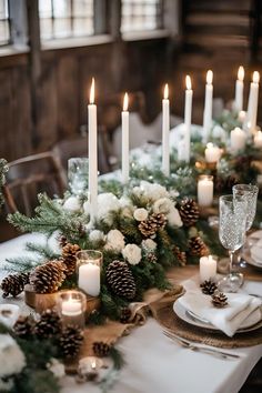 the table is set with candles, flowers and pine cones