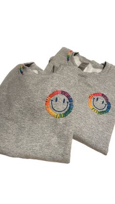 One of a Kind Adult Crewneck sweatshirt with Hand Embroidered Smiley. Each sweatshirt is custom and made to order with your preferences. Sweatshirt colour choice: Ash Grey (Light) or Sport Grey (Darker). Both are heathered grey.  Embroidery thread choice: smile can be made in your colour choice. Choose from 1 to 6 colours (for rainbow). Pastel, Bright or Neon colours. See pictures for examples. Indicate thread colour choice in the preference box.  if not choice is made, I will choose for you.  Size: Sweatshirts are unisex adult and range from SMALL to 3XL. Size up for more oversized fit.  Sweatshirt composition: cotton/polyester blend. Please note, since items are custom and made to order, they are final sale. However, if you have any issues with your order, please reach out. For more pics Starbucks Lovers, Vintage Crewneck, Simple Gift Wrapping, Collared Sweatshirt, Tie Dye Sweatshirt, Greek Clothing, Sorority And Fraternity, Neon Color, Hand Embroidery Stitches