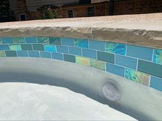 a hot tub with blue and green tiles on it