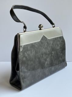 Fabulous 1960s shiny silver hard-case vinyl purse. Bag is large and roomy (see measurements below). Top clasp, handle strap. small inside pocket. Some slight wear to handle (see last photo). Overall excellent condition.  Height (purse body):  Strap: additional  Width (widest point): " Depth: " Label: original store label, "Townsend Shoes, Rome / Syracuse" Classic Silver Rectangular Bags, Silver Rectangular Classic Bag, Retro Silver Rectangular Bags, Retro Silver Rectangular Bag, Vintage Silver Handheld Bag, Vintage Silver Rectangular Bag, Vintage Shoulder Bag With Silver-tone Hardware, Vinyl Purse, 1960s Purse