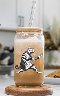 a mason jar with a tiger playing the guitar on it, sitting on a kitchen counter