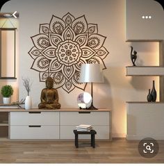 a buddha statue sitting on top of a wooden table in front of a white wall