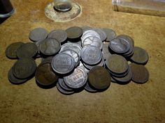 a pile of coins sitting on top of a wooden table