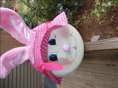 a pink bunny mask hanging from the side of a wooden fence