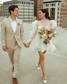 a man and woman holding hands while walking