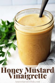 a mason jar filled with honey mustard and garnished with parsley on the side