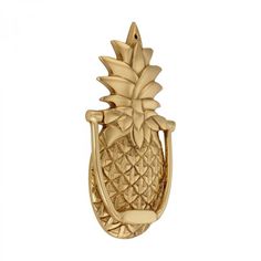 a gold pineapple shaped bottle opener on a white background