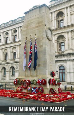 remembrance day parade in front of an old building with wreaths and flags on it