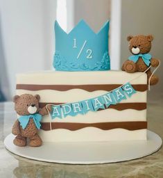 two teddy bears sitting on top of a cake with the number 12 on it's side