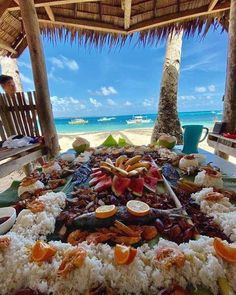 a large platter of food on a table at the beach