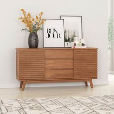 a wooden dresser sitting in front of a white wall with pictures on top of it