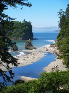 the beach is surrounded by trees and water