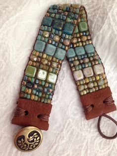 a pair of brown and blue beaded belt with metal buckles on white fabric