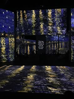 the starry night sky is reflected in water with people looking at it from across the room