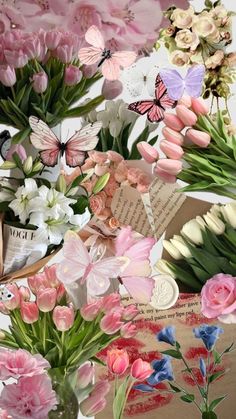 an arrangement of flowers and butterflies in a vase on a table next to a book