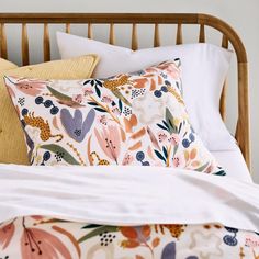 a bed topped with pillows and blankets next to a wooden headboard