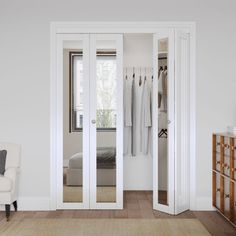 an open closet with clothes hanging on the wall and a chair in front of it