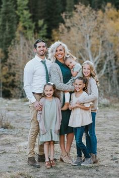 a family posing for a photo in the woods