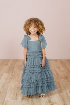 Let your little one twirl away in our Tallulah Tulle dress. Tallulah features a square neckline with one layer of tulle straps that self-tie into bows and is finished with a tiered ruffle skirt. Perfect for the flower girl that loves to dance the day away! Model Spencer; Size: 3T / Length: Regular, Age: 3, Height: 3'5 Model Marleese; Size: 4T / Length: Regular, Age: 5, Height: 3'8 FEATURES: Flowy A-line silhouette Square neckline Self-tie spaghetti straps Back zipper Full-length double lining fo Ruffle Flower Girl Dress, Tulle Lights, Tulle Straps, Black Tie Attire, Wedding Parties Colors, Dusty Blue Wedding, Tiered Ruffle Skirt, Wedding Black, Dusty Blue Weddings