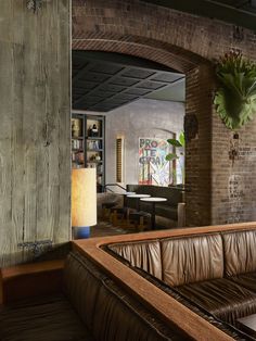 a living room filled with furniture next to a brick wall