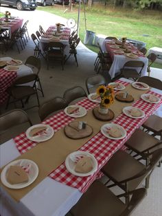 the tables are set up with red and white checkered tablecloths, sunflowers, and plates