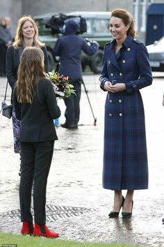 a woman in a blue coat talking to another woman