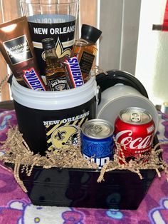 a bucket filled with drinks and snacks on top of a table