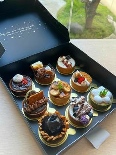 a box filled with lots of different types of desserts on top of a table