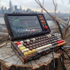 an open laptop computer sitting on top of a tree stump