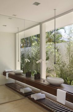 a bath room with a large window and a bowl on top of the counter next to it