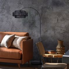 a living room with a couch, table and chair next to a lamp on the wall