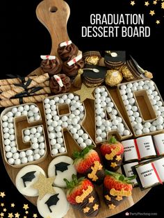 graduation dessert board with chocolate covered strawberries, cookies and candies in the shape of letters