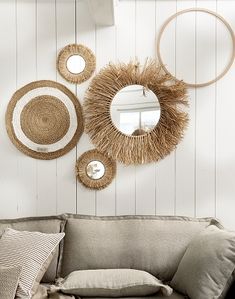 a living room filled with furniture and mirrors on the wall above it's headboard