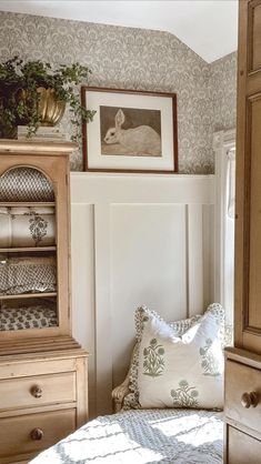 a bedroom with a bed, dresser and pictures on the wall