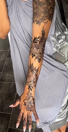 a woman's arm with henna tattoos on it