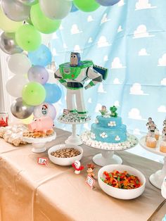 a table topped with lots of food and balloons