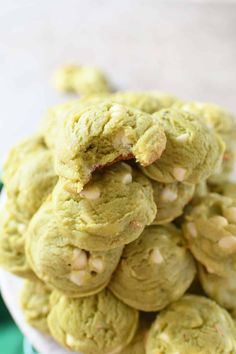 a pile of cookies sitting on top of a white plate next to a green napkin