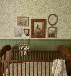 a baby crib in a room with pictures on the wall