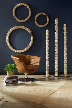 a chair sitting in front of a blue wall next to two wooden circles on the wall