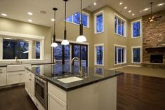 a large kitchen with an island in the middle and windows on both sides that look out onto trees