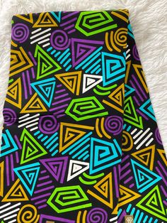 a colorful tie on a white furnishing with black background and multicolored shapes