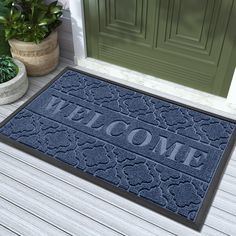 a blue welcome mat with the word welcome on it in front of a green door