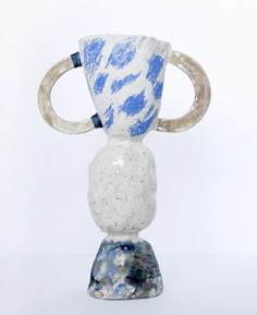 a blue and white vase sitting on top of a marble base with an oar sticking out of it