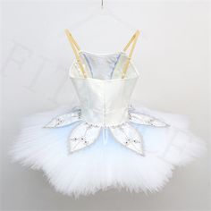 a white tutu and ballet outfit hanging on a hanger