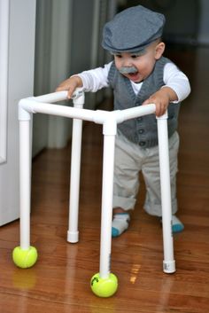 a toddler playing with tennis balls in front of a white rail on the floor