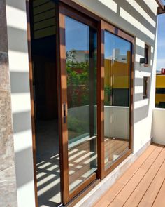 an outside view of a house with wooden decking and sliding glass doors