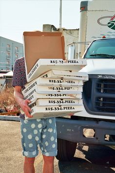 a man standing in front of a truck with boxes on his back